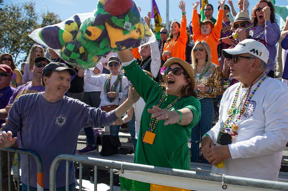 A woman catches a bag of stuffed animals during the Gulf Coast Carnival Association Mardi Gras Parade in Biloxi on Tuesday, March 1, 2022.