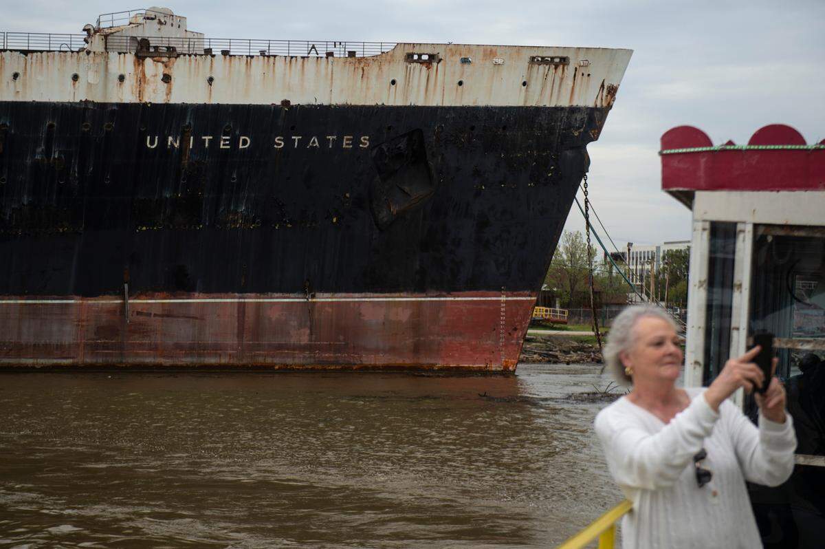 Passengers on The Perdido Queen take photos of the SS United States as it is docked in Mobile on Friday, March 28, 2025.