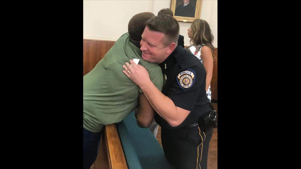 Leontyne Daily, sister of the shooting victim Fabian Dailey, hugs Moss Point Police Chief Brandon Ashley after a press conference announcing four arrests in the killing on Wednesday, Aug. 22, 2018.