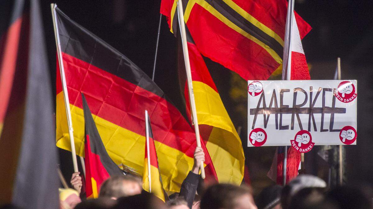 Thousands of people take part in a demonstration initiated by the Alternative for Germany (AfD) party against uncontrolled immigration in Erfurt, central Germany, Wednesday, Oct. 21, 2015. The banner reads: 'Merkel, no thanks'. (AP Photo/Jens Meyer)