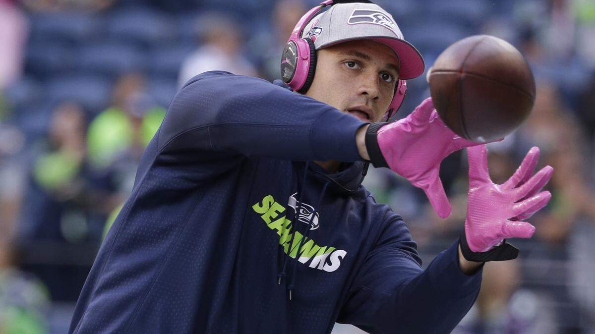 Seattle Seahawks tight end Jimmy Graham wears pink headphones and other items for breast cancer awareness during warmups before an NFL football game against the Detroit Lions in the first half of an NFL football game, Monday, Oct. 5, 2015, in Seattle. (AP Photo/Elaine Thompson)