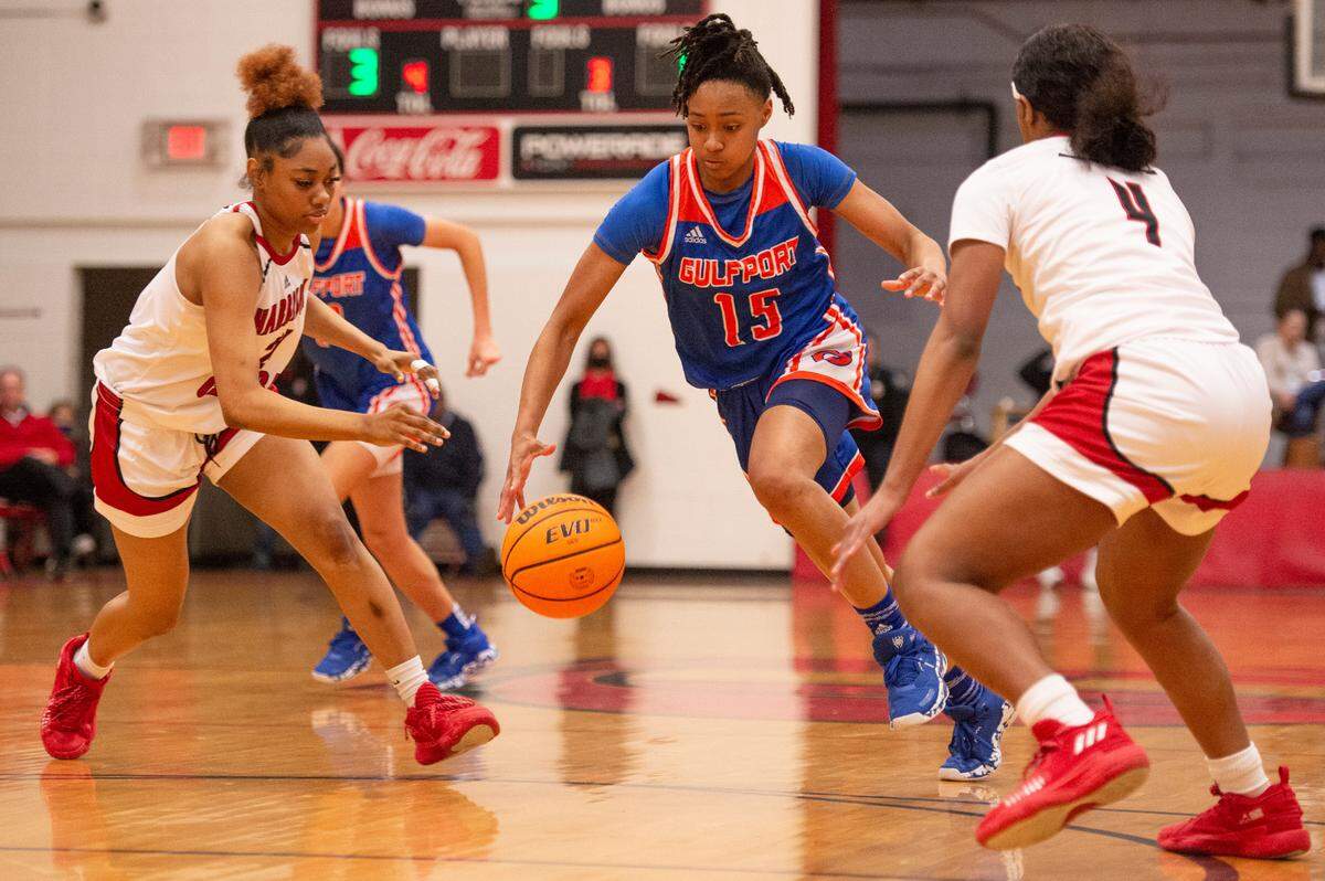 Gulfport’s Simaru Fields, center, dribbles the ball between Harrison Central’s Hanna Travis, right, and A’Me Sardin during a game against Harrison Central at Harrison Central High School in Gulfport on Friday, Feb. 4, 2022.