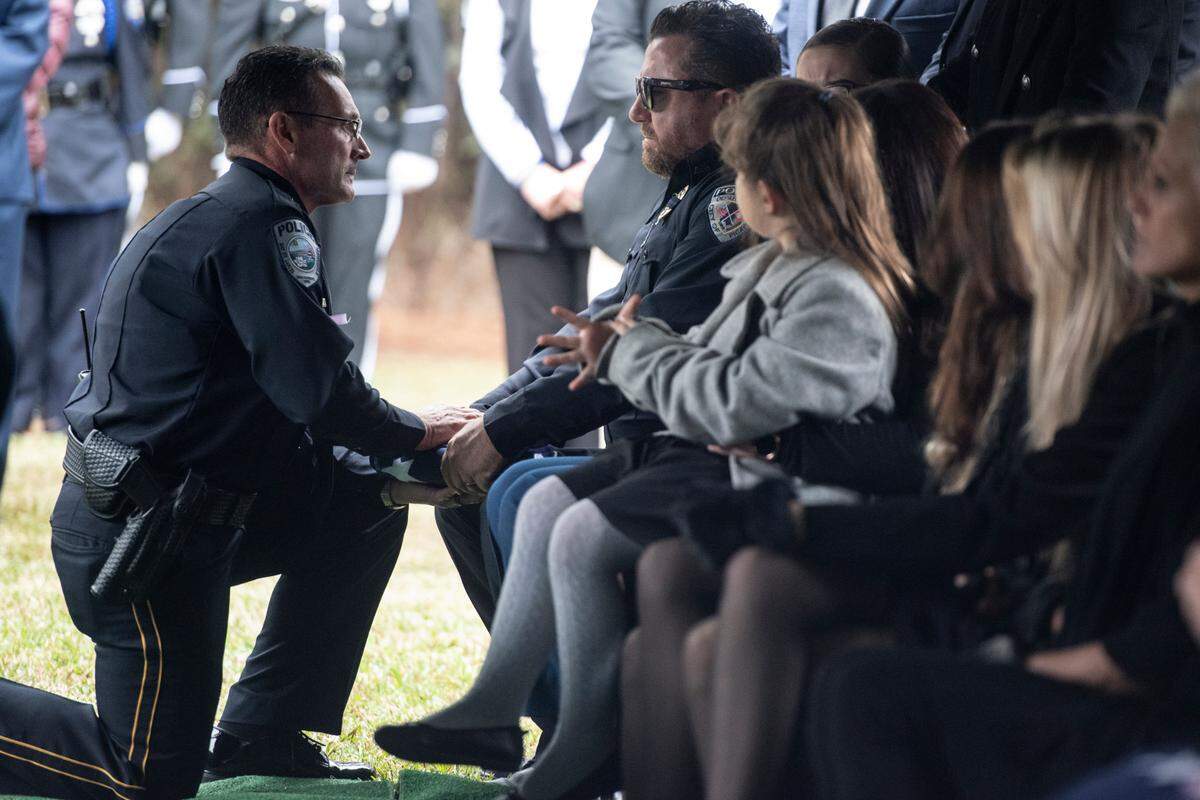 Bay St. Louis Police Chief Toby Schwartz presents a folded flag to Branden Estorffe’s dad Ian, a fellow police officer, during the funeral of Bay St. Louis police officers Sgt. Steven Robin and Branden Estorffe at Gardens of Memory cemetery in Bay St. Louis on Wednesday, Dec. 21, 2022. Robin and Estorffe were killed responding to a call at a Motel 6 on Dec. 14.