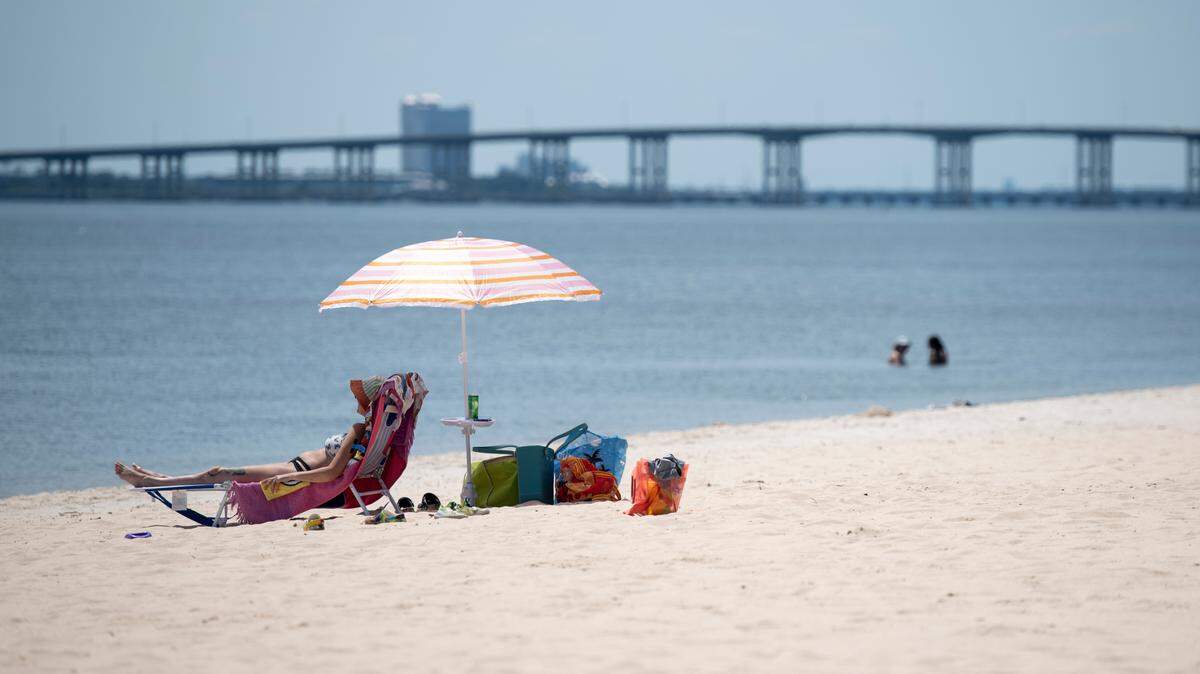 A beachgoer sits at East Beach in Ocean Springs on Tuesday, June 11, 2024. Ocean Springs is proposing to build a pedestrian walkway on the beach but many residents who live in the area are opposed.