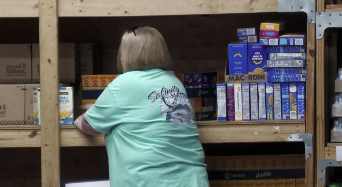A Petal Children’s Task Force employee sorts food donations at the facility in Petal, ahead of an expected summer surge in assistance requests, Feb. 25, 2025.