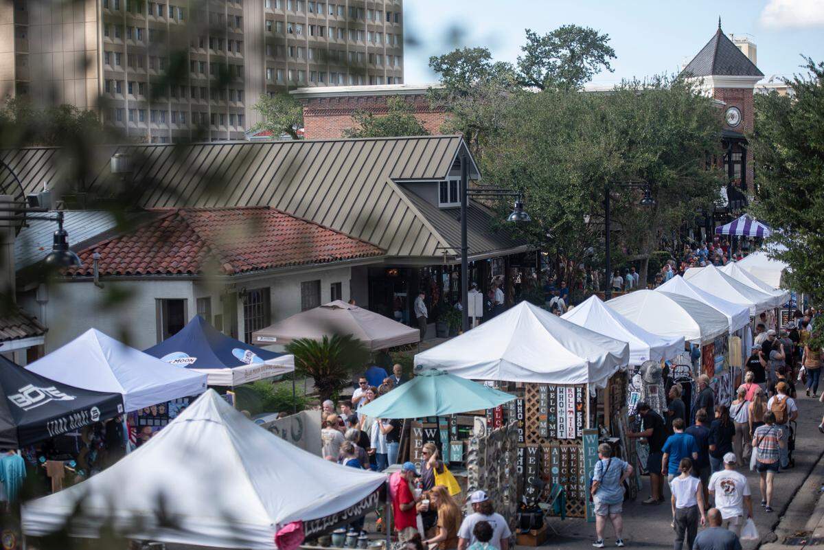 People walk among tents selling art along Government Street during the Peter Anderson Festival in Ocean Springs in 2022. This year they’ll be able to duck into the new Eleven IX Lounge for a craft cocktail or martini.