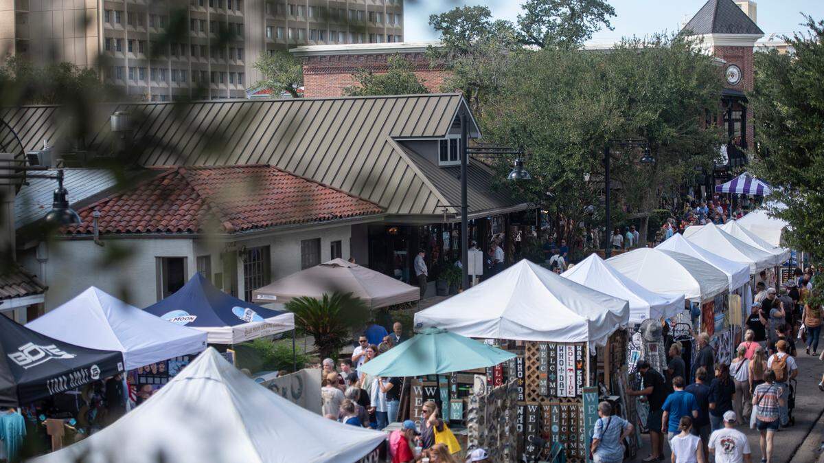 People walk among tents selling art along Government Street during the Peter Anderson Festival in Ocean Springs on Sunday, Nov. 6, 2022. 