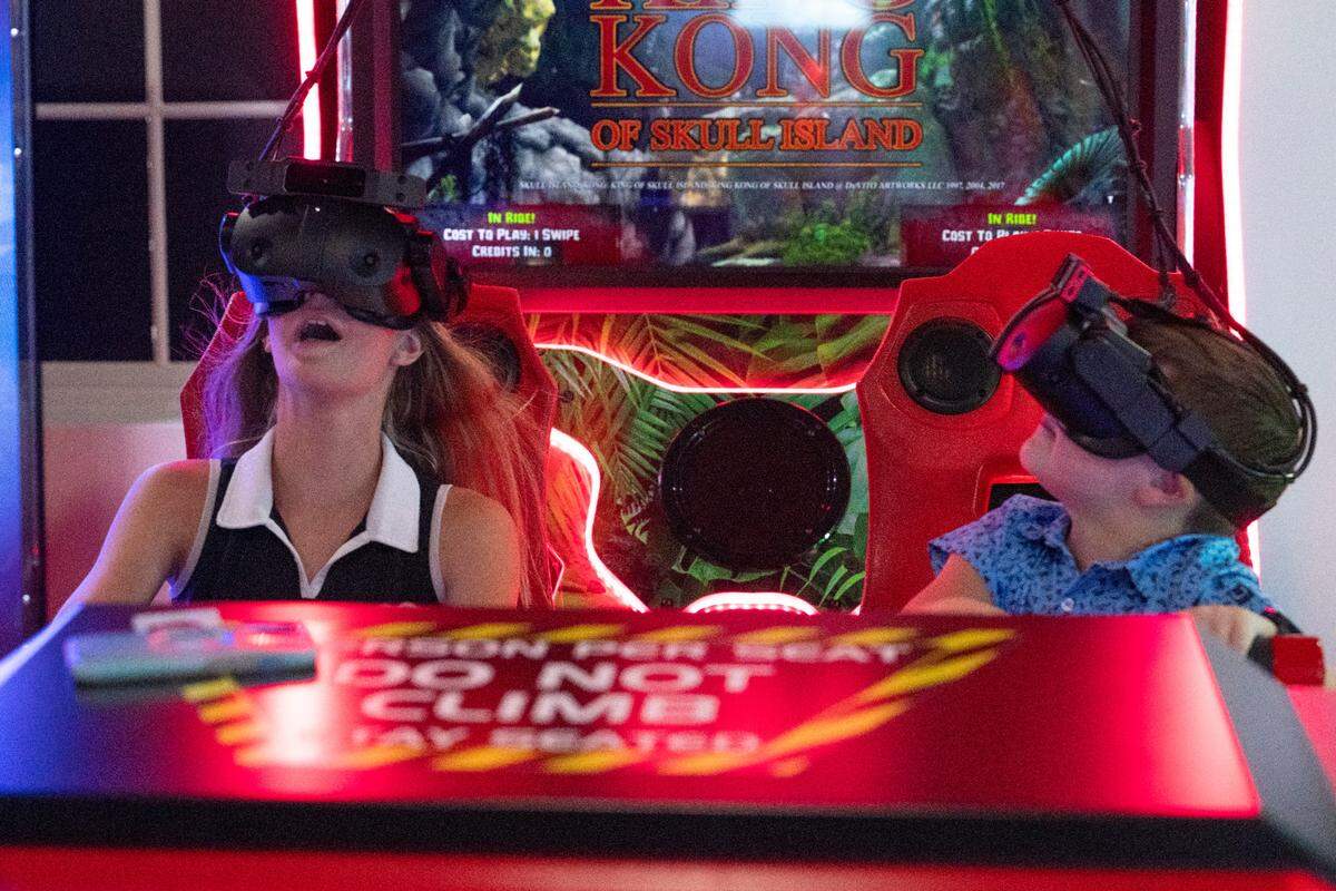 Visitors play a virtual reality game at Hippie Fish at Centennial Plaza in Gulfport on Thursday, June 26, 2025.
