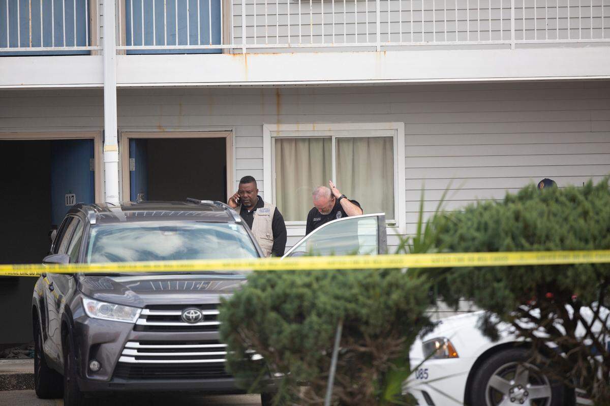 Authorities examine a Toyota SUV in the parking lot of Motel 6 on Dec. 14, 2022, after two Bay St. Louis police officers were killed while responding to a call.