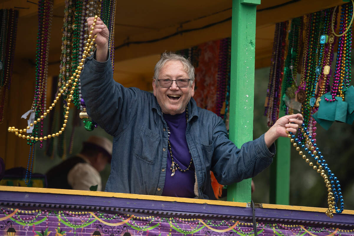 A float rider throws beads during The Ocean Springs Elks Carnival Parade in downtown Ocean Springs on Saturday, Jan. 27, 2024.