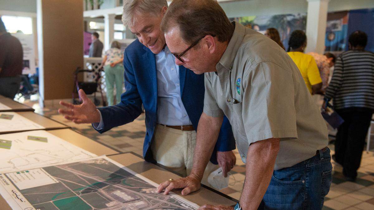 Gulfport Mayor Billy Hewes looks over plans for a potential road development with environmental lawyer Robert Wyigul at a public hearing at Gulfport Premium Outlets on Wednesday, July 13, 2022. The plan has faced criticism from nearby residents that it will have negative environmental impacts and cause more flooding.