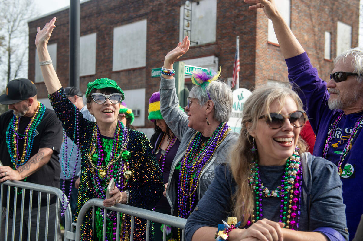 Parade attendees cheer for beads during The Ocean Springs Elks Carnival Parade in downtown Ocean Springs on Saturday, Jan. 27, 2024.