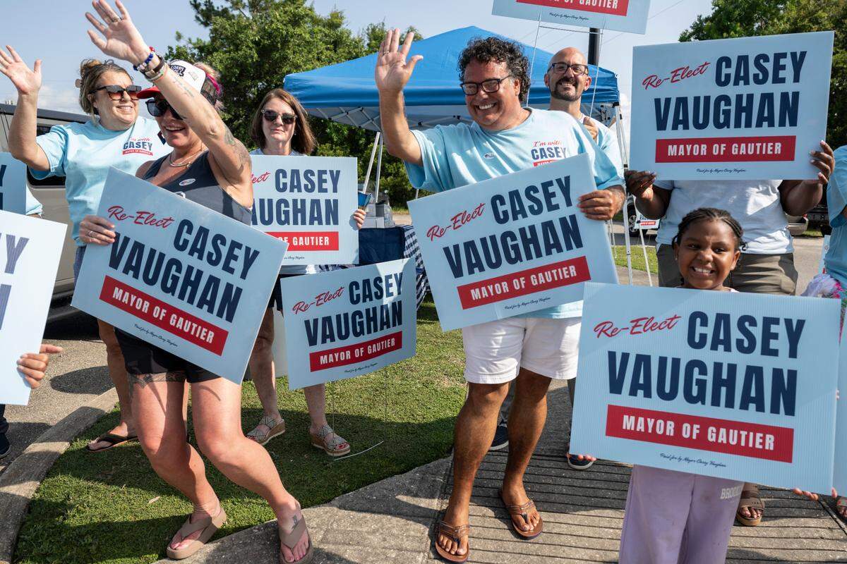Casey Vaughan, center, a candidate for mayor of Gautier, waves to cars with his supporters outside of Gautier Public Library on Election Day, Tuesday, June 3, 2025.