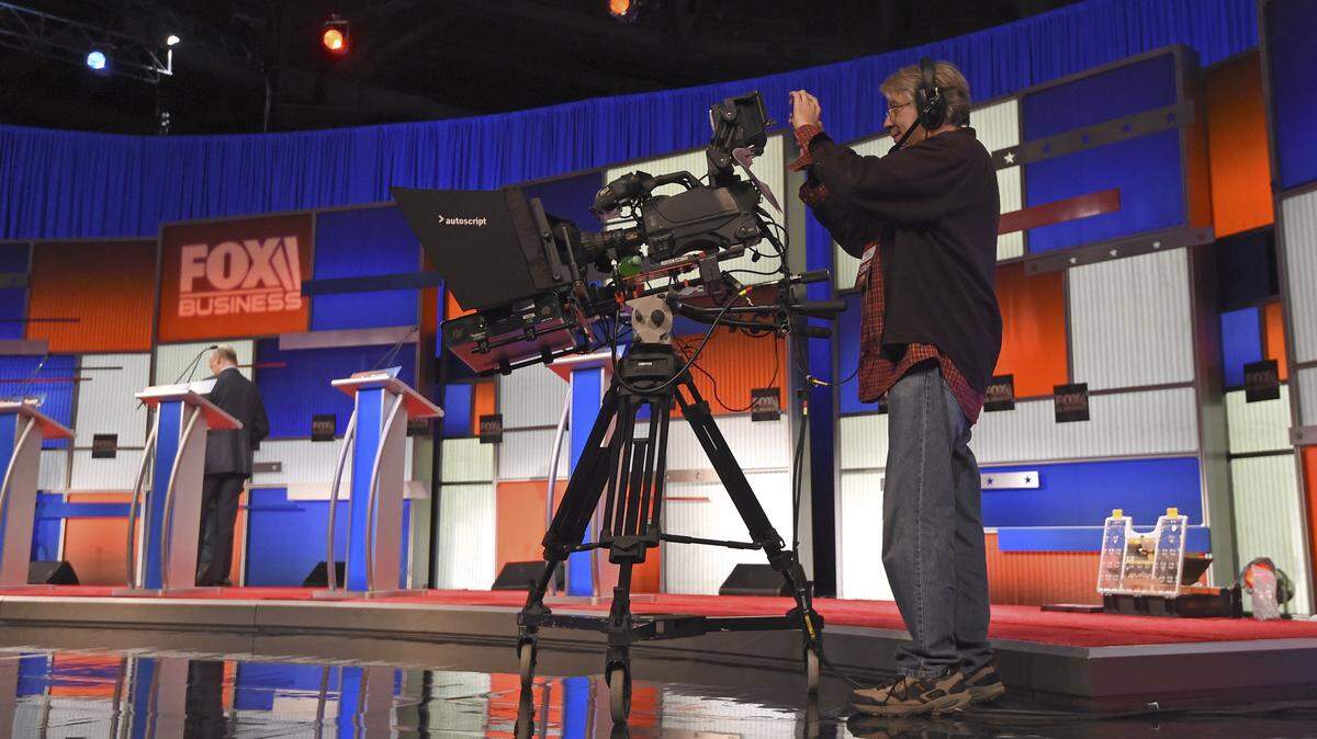 Cameraman Joe Schmitt takes a photo with his cell phone as the crew sets up the stage at the North Charleston Coliseum, Wednesday, Jan. 13, 2016, in North Charleston, S.C., in advance of Thursday's Fox Business Network Republican presidential debate. (AP Photo/Rainier Ehrhardt)