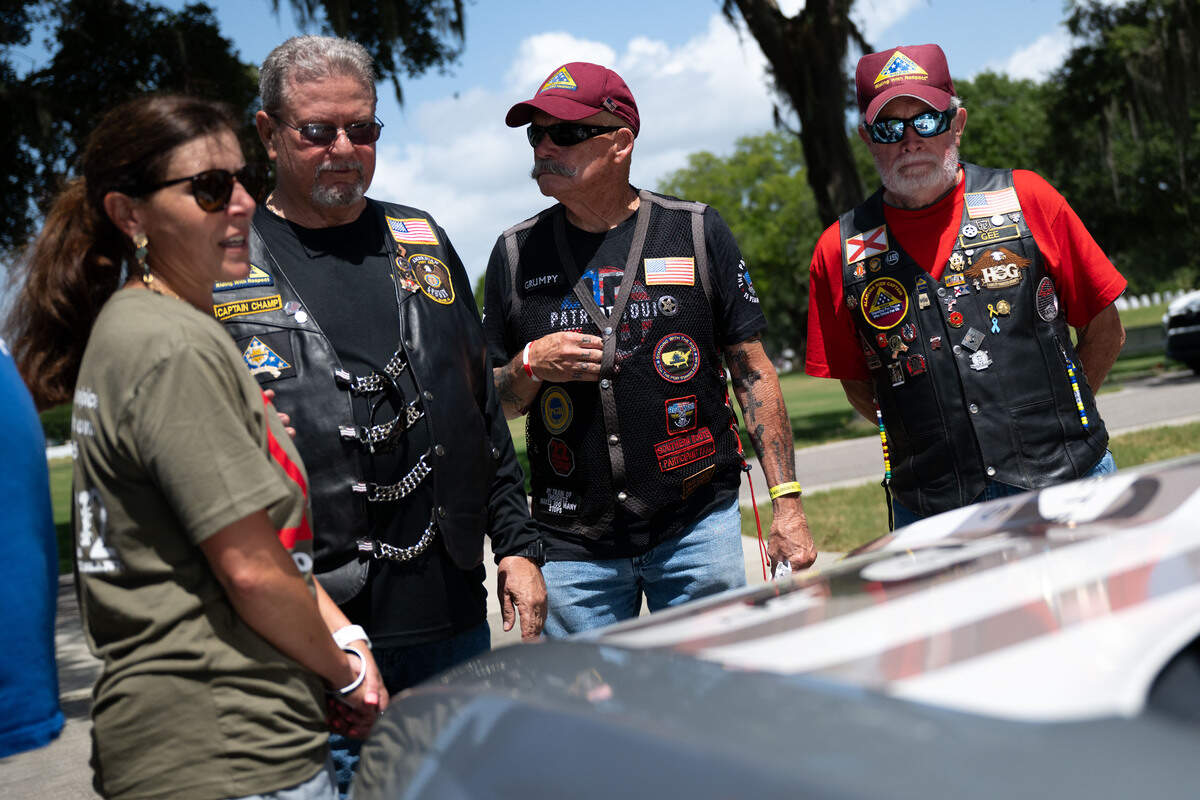 Mejia Gex Johnson, left, shows veterans with the Nation of Patriots a car dedicated to her son Matthew Locascio, a veteran who died by suicide, during a ceremony at Biloxi National Cemetery on Saturday, July 11, 2026.
