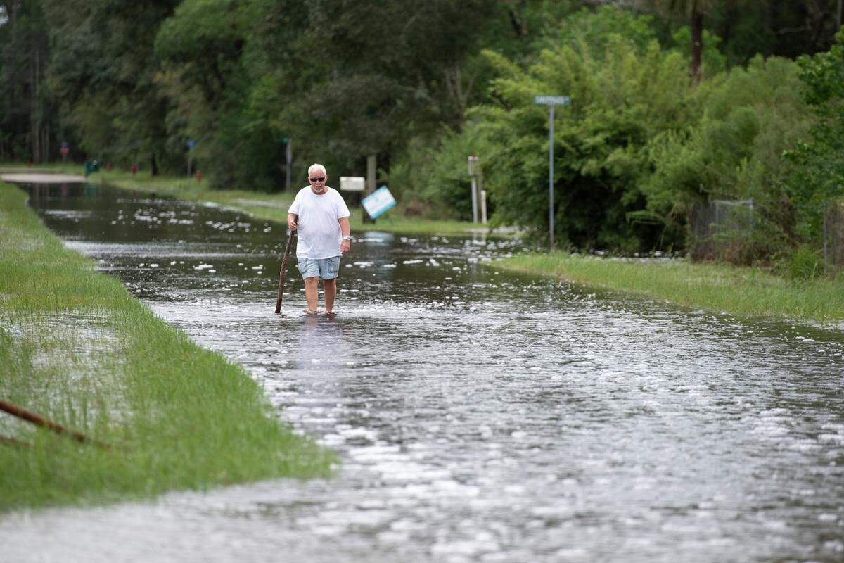 A man walks through floodwaters along Tigris Street in Shoreline Park after Hurricane Francine on Thursday, Sept. 12, 2024.