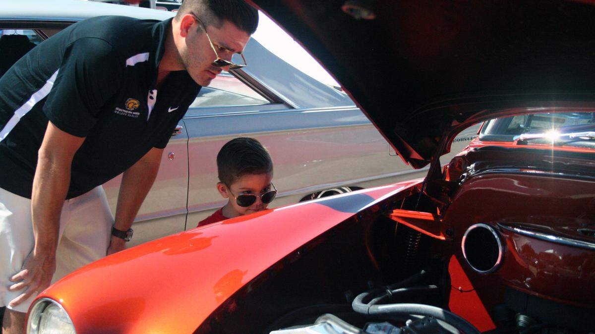 SHANNON DAVIDSON/SPECIALTOTHESUNHERALDJeremy Hard and his son, Mac, of Biloxi look at the engine of a 1951 Chevy coupe owned by Jim and Brenda Thomas of Stockbridge, Ga., during the Biloxi Downtown Block Party on Wednesday.