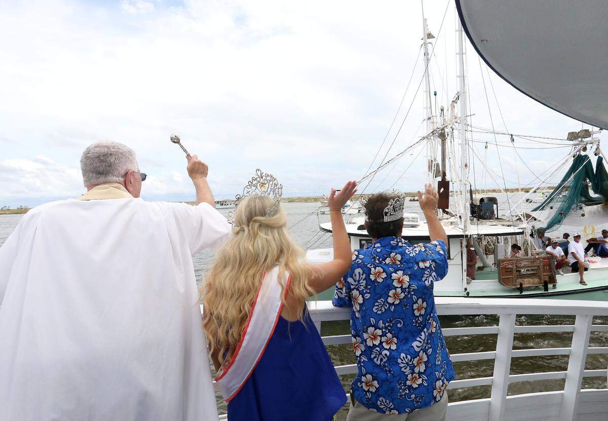 JOHN FITZHUGH/SUN HERALDThe Rev. Greg Barras blesses a passing shrimp boat as Shrimp Queen Paige Jimmerson and Shrimp King Frank Parker wave during the 2016 Biloxi Blessing of the Fleet in the Biloxi Channel on Sunday June 5, 2016.
