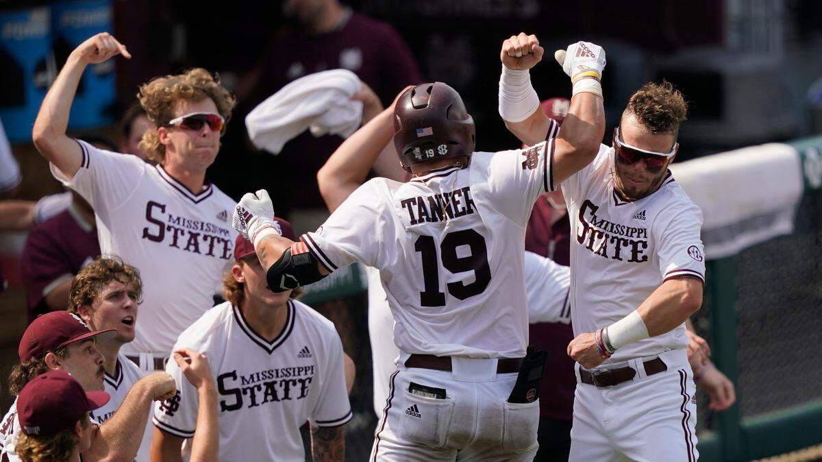 Mississippi State’s Logan Tanner (19) is congratulated by teammates after hitting a home run against Notre Dame during the seventh inning of an NCAA college baseball super regional game, Saturday, June 12, 2021, in Starkville, Miss. (AP Photo/Rogelio V. Solis)