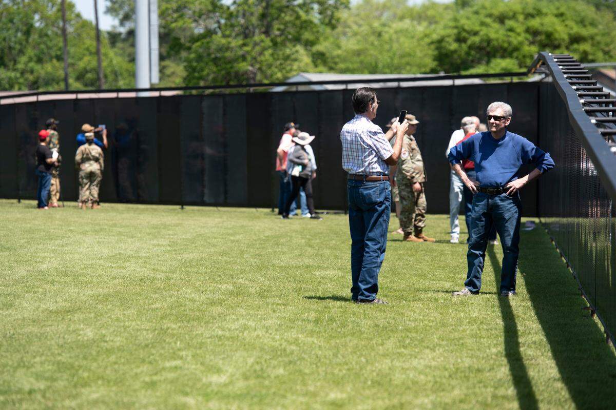 Visitors take photos with The Wall That Heals, a traveling three-quarter scale replica of the Vietnam Veterans Memorial in D.C., while it is on display at the D’Iberville Sports Complex in D’Iberville on Thursday, April 10, 2025.