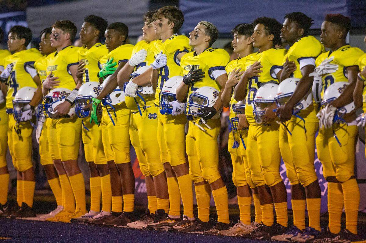 The St. Martin Yellowjackets stand for the anthem before a game against Hancock wearing special social media themed jerseys with their own hashtag and social media handles on them at Joe Barlow Stadium in St. Martin on Friday, Sept. 30, 2022.