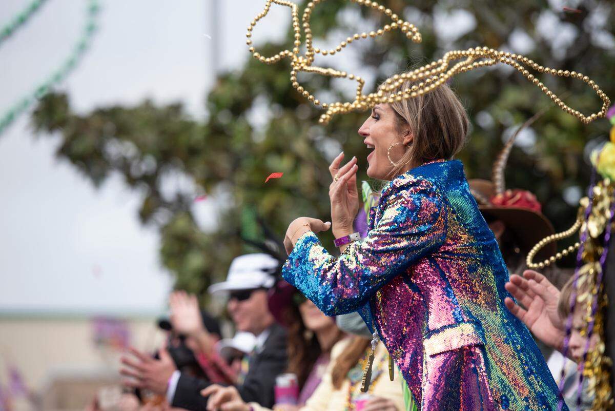 Parade watchers catch beads and other throws during the Gulf Coast Carnival Association Mardi Gras parade in Biloxi on Tuesday, March 4, 2025.