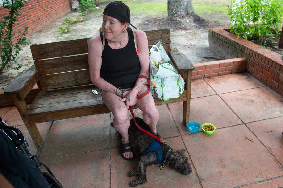 Amanda Thorne, who is experiencing homelessness, and her dog Batman outside of the St. Vincent de Paul Society at Our Lady of Fatima Catholic Church in Biloxi on Thursday, Sept. 5, 2024. Thorne, who is from Biloxi, said she has been a victim of assault while being forced to live on the streets. She is one of many homeless people who have camped on the Broadwater property.