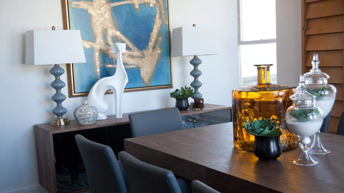 TNSAn oversized piece of art with a deep blue background serves as a visual anchor in this dining room.