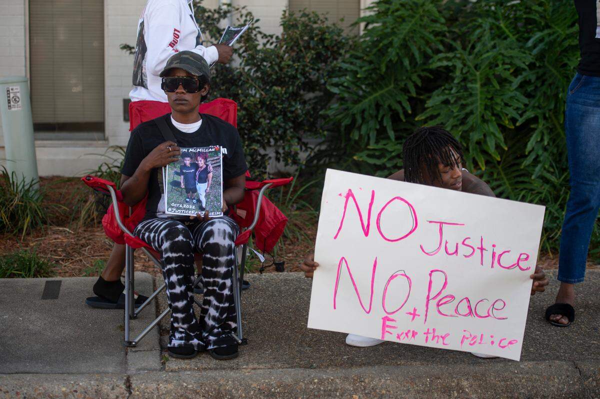 Katrina McMillan holds signs seeking justice for her son Jaheim McMillan, a 15-year-old Gulfport High student who was shot by police outside a Family Dollar Store, during a protest outside the Gulfport Police Station in Gulfport on Tuesday, Oct. 11, 2022.