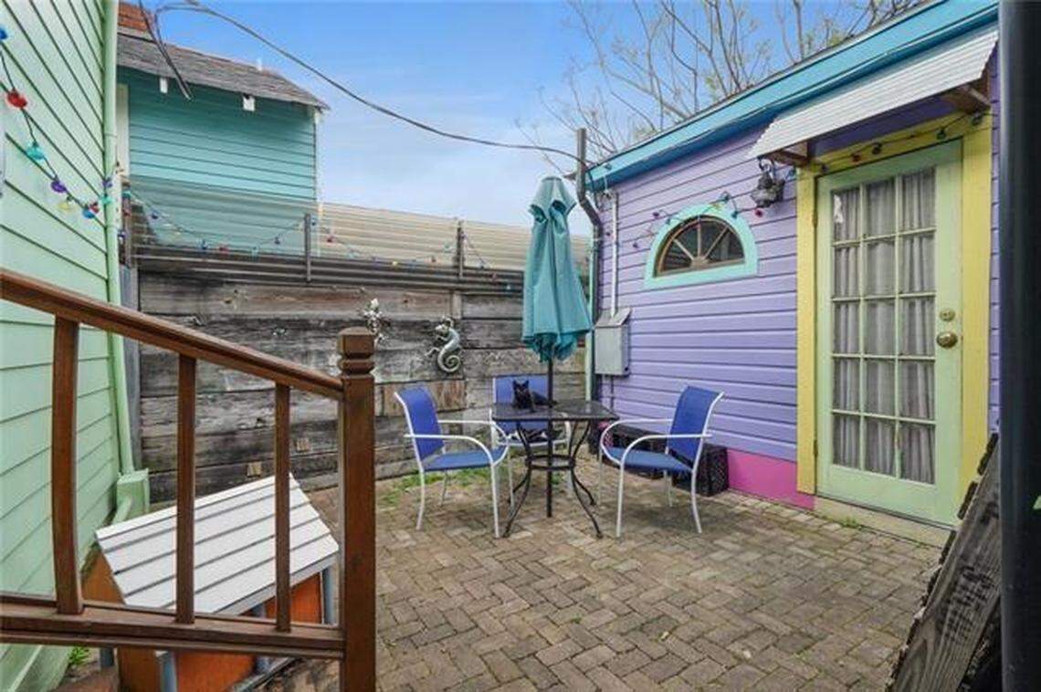 A black cat relaxes on the “catio” at the rear of the home.