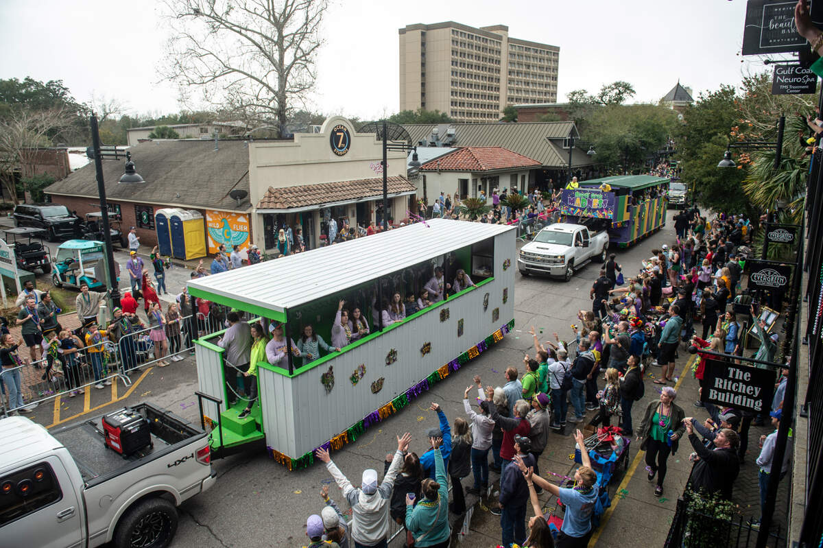 Parade attendees cheer for beads as floats pass by during The Ocean Springs Elks Carnival Parade in downtown Ocean Springs on Saturday, Jan. 27, 2024.