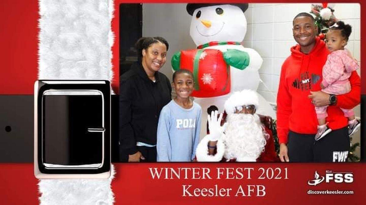 Lonnald Carter poses with a family while portraying Santa at the Keesler Air Force Base Winter Fest on Dec. 3, 2021.