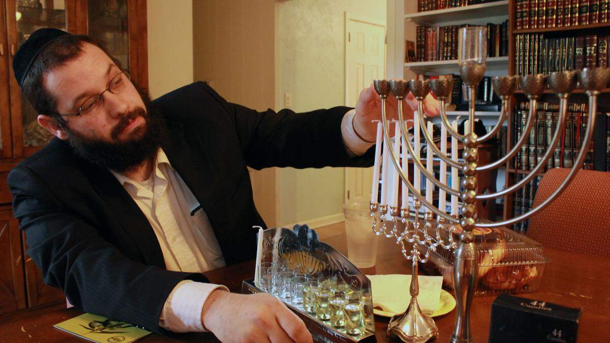 JEFF CLARK/SUN HERALDRabbi Akiva Hall, the leader of Chabad of Southern Mississippi, explains the significance of the menorah as he prepares for Hanukkah. The Jewish holiday will be celebrated through Dec. 14.