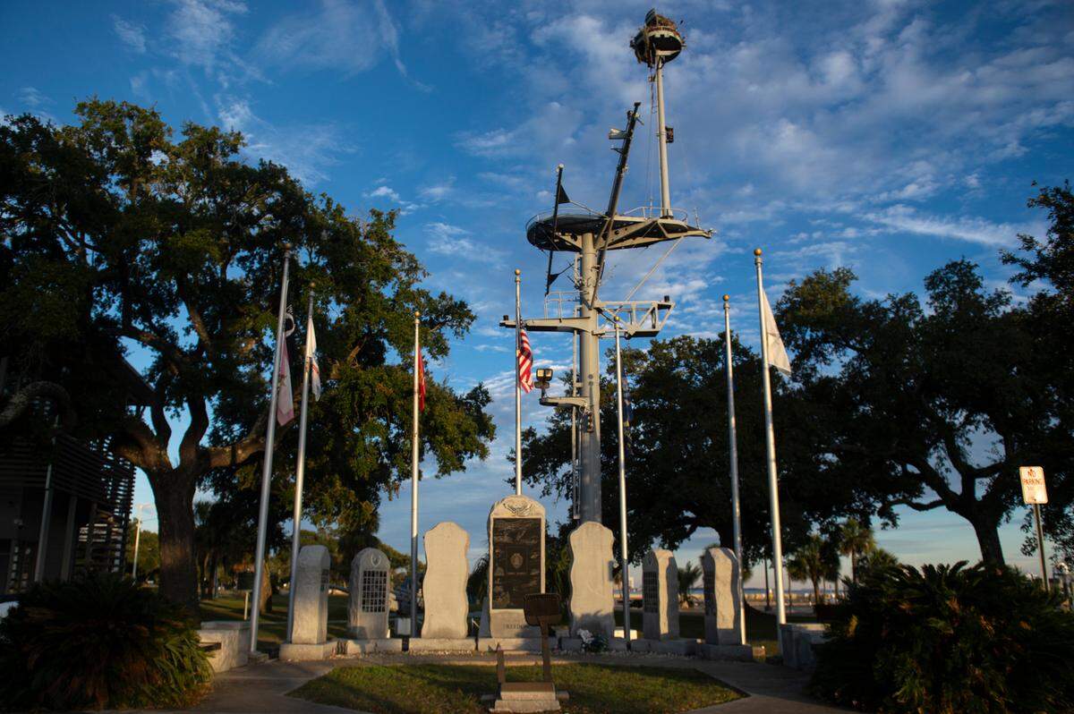 The mast of the U.S.S. Biloxi, which is now part of its memorial, sits behind the WWII memorial at Guice Park in Biloxi on Monday, Nov. 27, 2023.