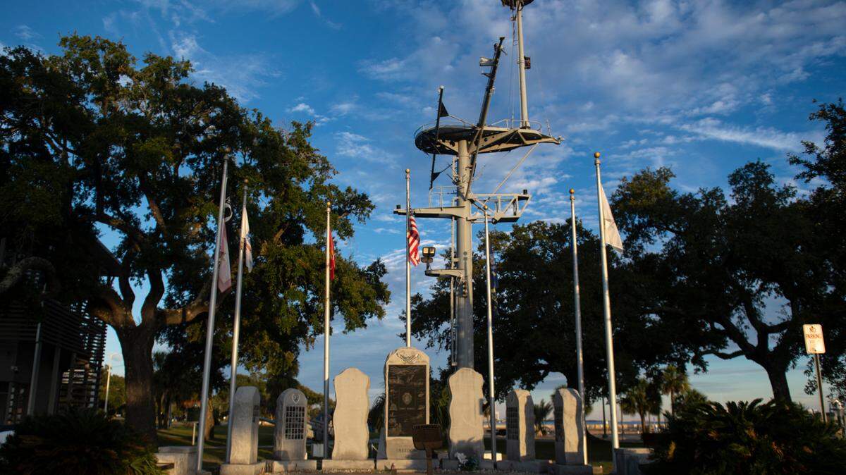 The mast of the U.S.S. Biloxi, which is now part of its memorial, sits behind the WWII memorial at Guice Park in Biloxi last year.