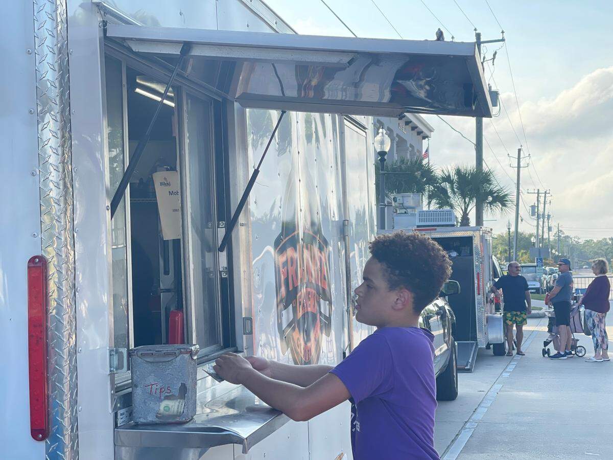 A boy orders at Frankie Faye’s Good Eatin’ food truck in Waveland at Food Truck Friday on Coleman Avenue.