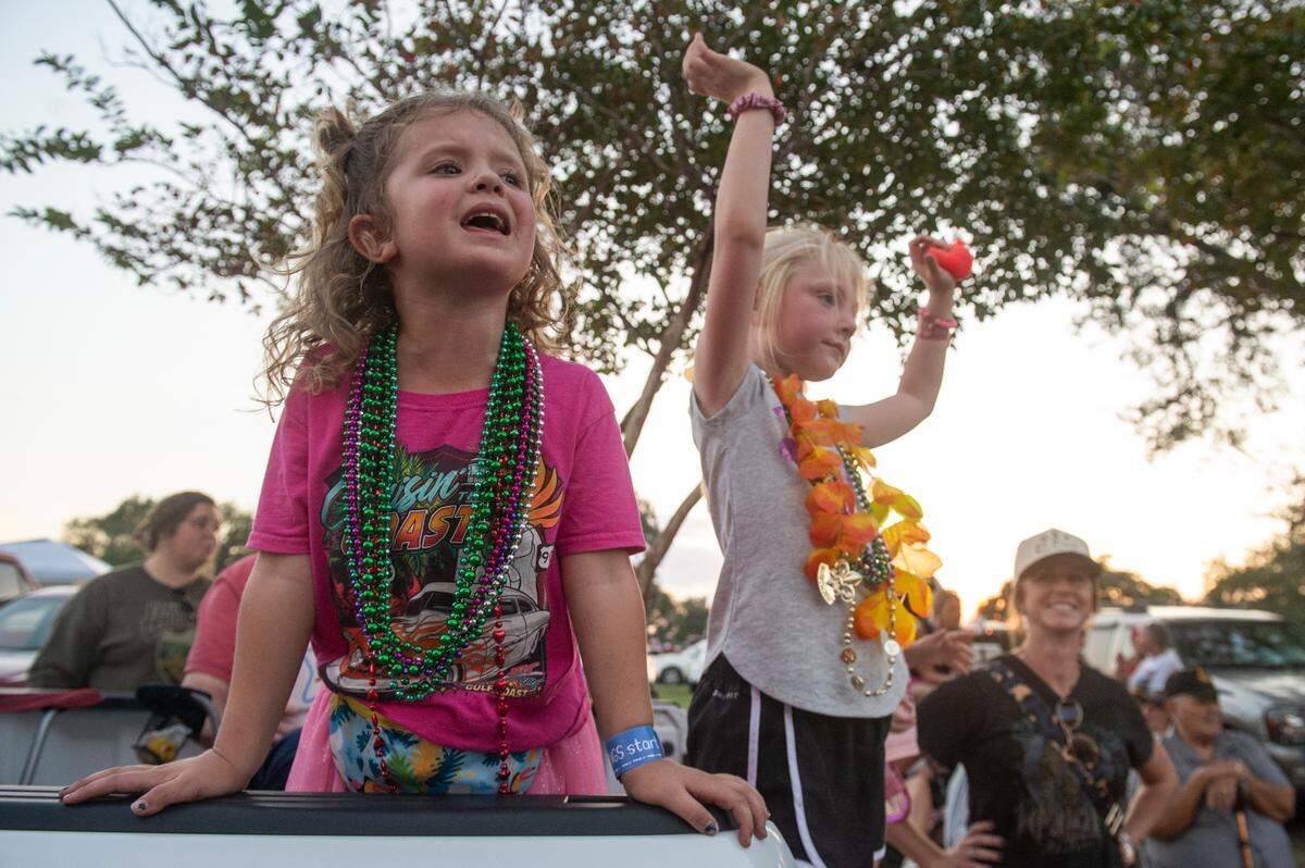 Evelyn Malley, left, and Emerson Gale wave to the Cruisers during the Long Beach Parade in Long Beach, one of the events in Cruisin’ The Coast, on Monday, Oct. 7, 2024.