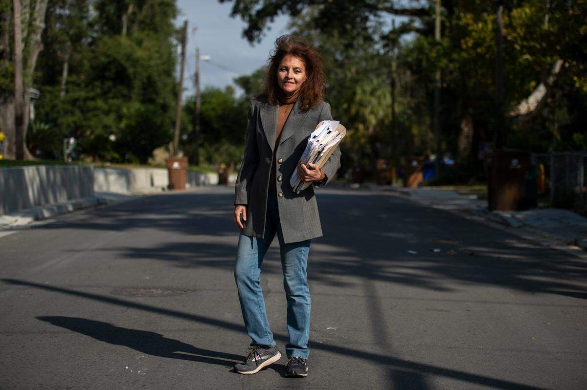 Lela Jordan stands in the middle of Benachi Avenue in Biloxi with a stack of paperwork she’s been accumulating on the Biloxi public works project on Friday, Nov. 5, 2021. Since moving back to Biloxi from Florida, Jordan has been pushing the city of Biloxi fix driveways and sidewalks that were improperly installed.