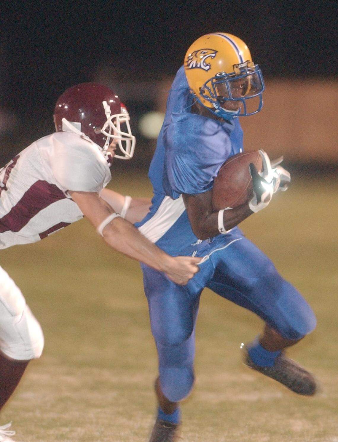 Bay High running back Robert Labat(1) slips a tackle attempt by Long Beach strong safety William Wicks(20) on a first-quarter carry during their game against Long Beach on Sept 26, 2005.