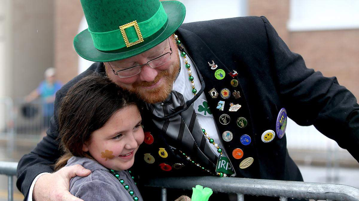 AMANDA McCOY/SUN HERALDIsabel Fults, 9, gets a hug from a member of the Ole Biloxi Marching Club during Biloxi's Hibernia Parade on Saturday.