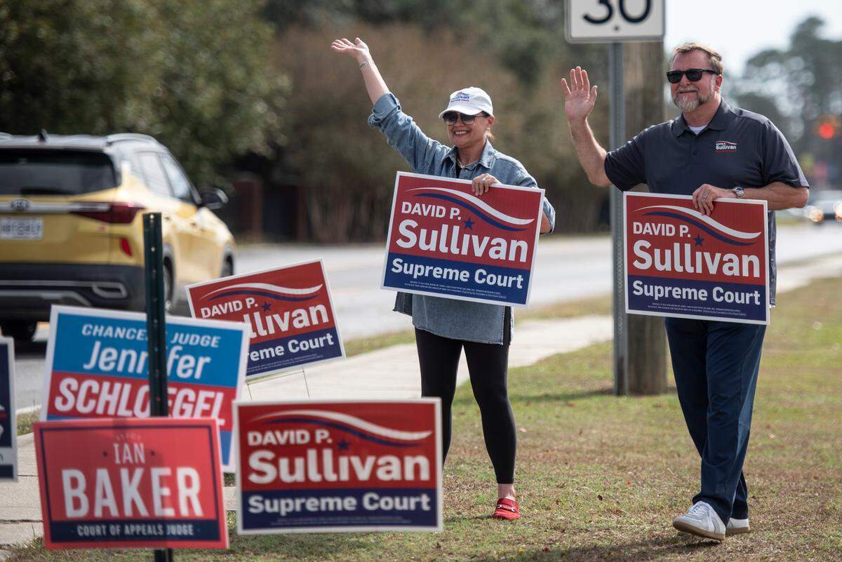 David P Sullivan and his wife, Stefany Sullivan, campaign for his run for Mississippi Supreme Court outside the D’Iberville Civic Center in D’Iberville on Tuesday, Nov. 5, 2024.