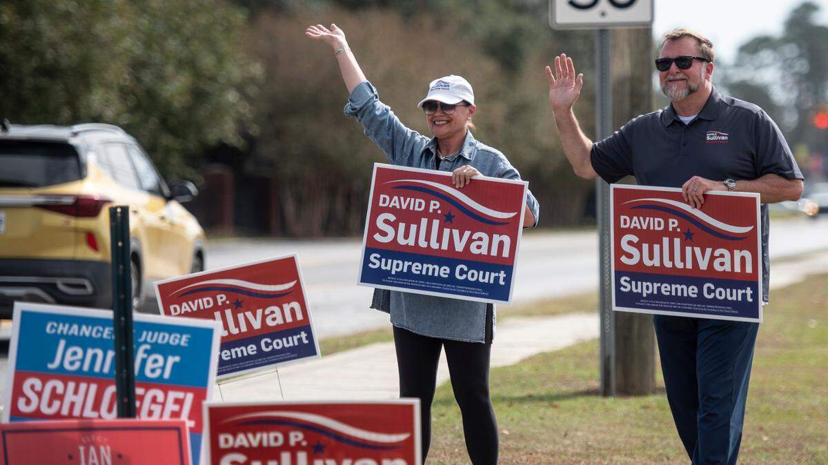 David P Sullivan and his wife, Stefany Sullivan, campaign for his run for Mississippi Supreme Court outside the D’Iberville Civic Center in D’Iberville on Tuesday, Nov. 5, 2024.