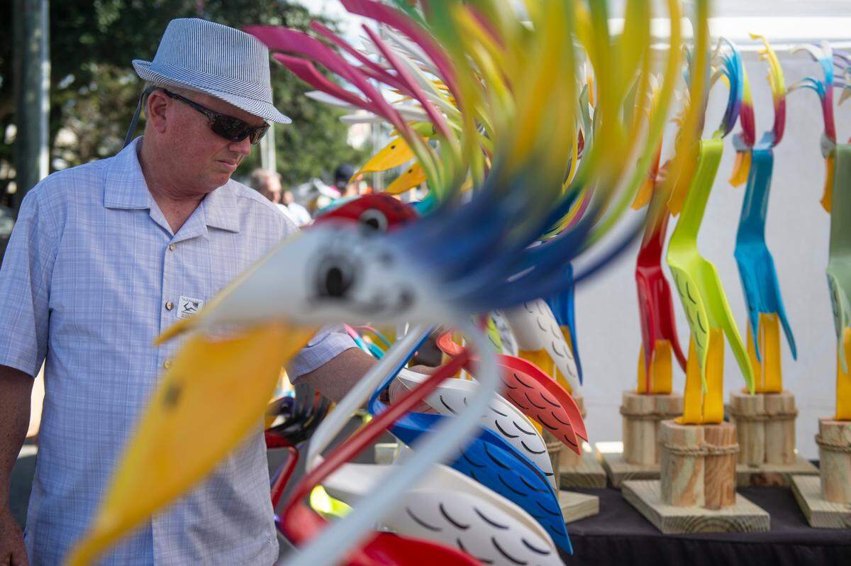 A customer admires flamingos made of PVC pipe for sale during the Peter Anderson Festival in Ocean Springs on Sunday, Nov. 6, 2022.