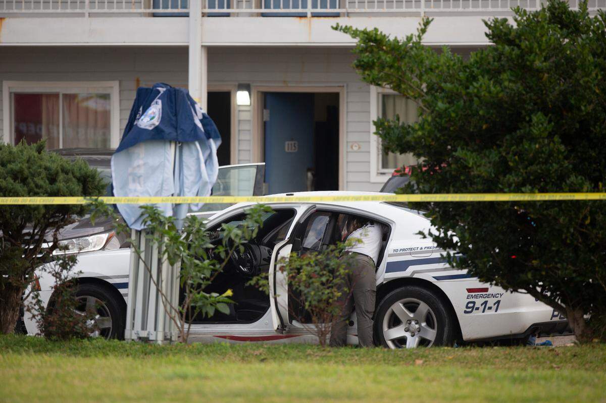 The Mississippi Bureau of Investigation examines in the inside of a Bay St. Louis police car outside of Motel 6 on Dec. 14, 2022. Two Bay police officers were shot and killed while responding to call there.