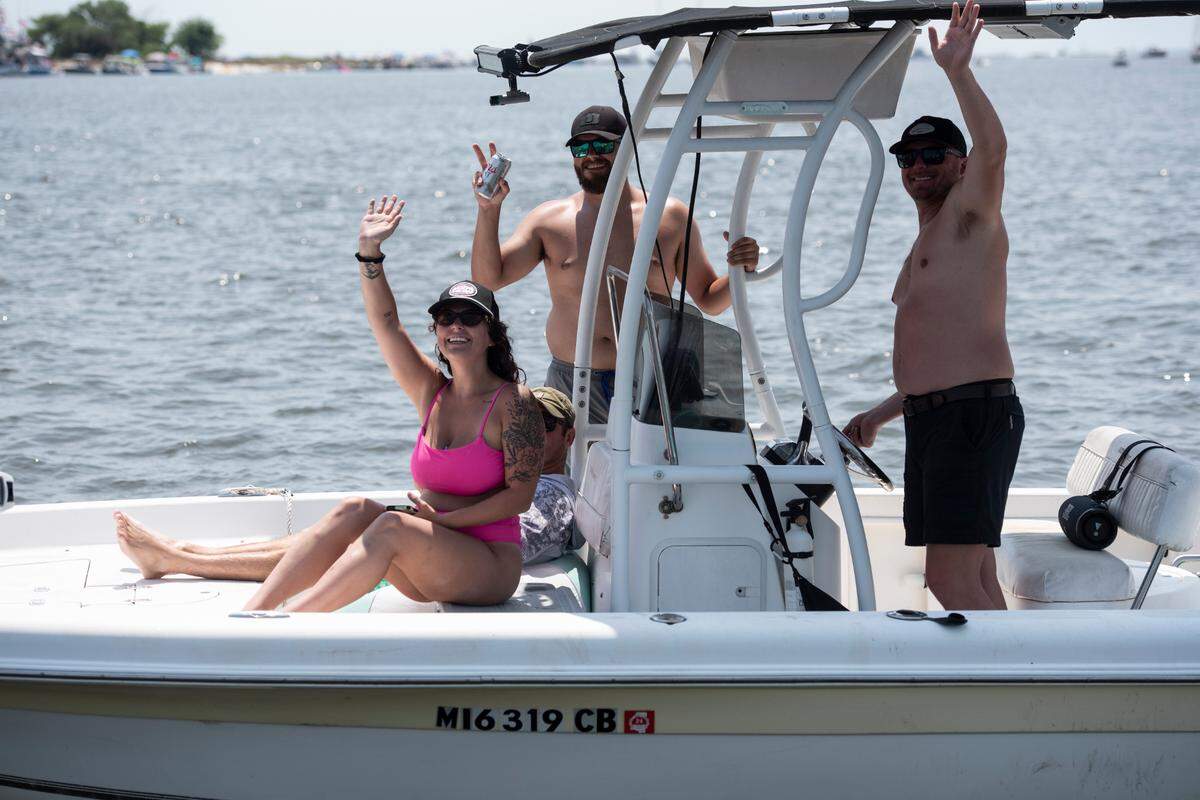 People on a boat wave to Msgr. Dominick Fullam and the Shrimp King and Queen as they receive a blessing during the Blessing of the Fleet in Biloxi on Sunday, May 28, 2023.