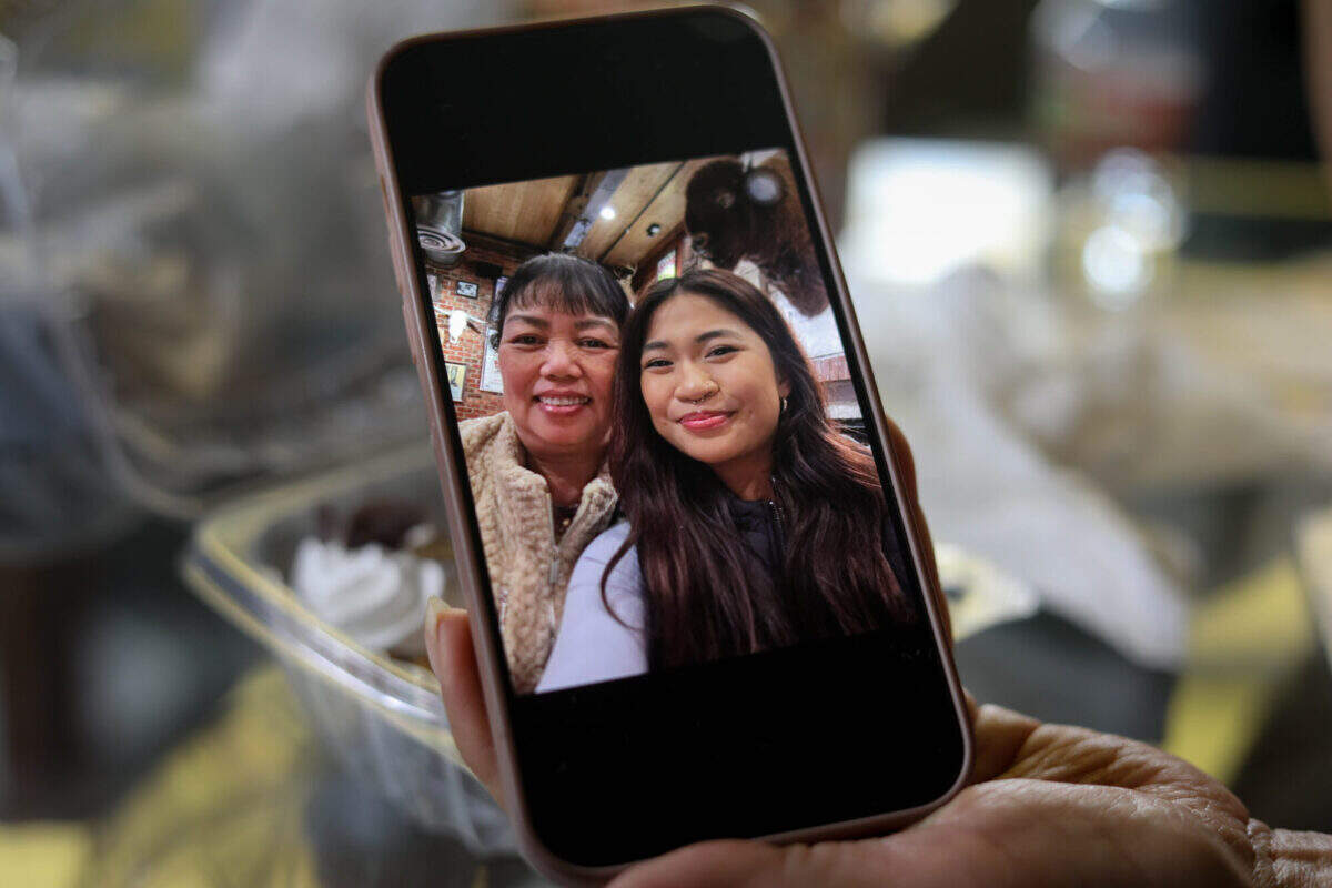 Coi Nguyen holds a photo of herself and her daughter, Annie, who is in her last year of nursing school. The decision to become a nurse was influenced by her mother and her family’s dedication to helping others, Annie said.