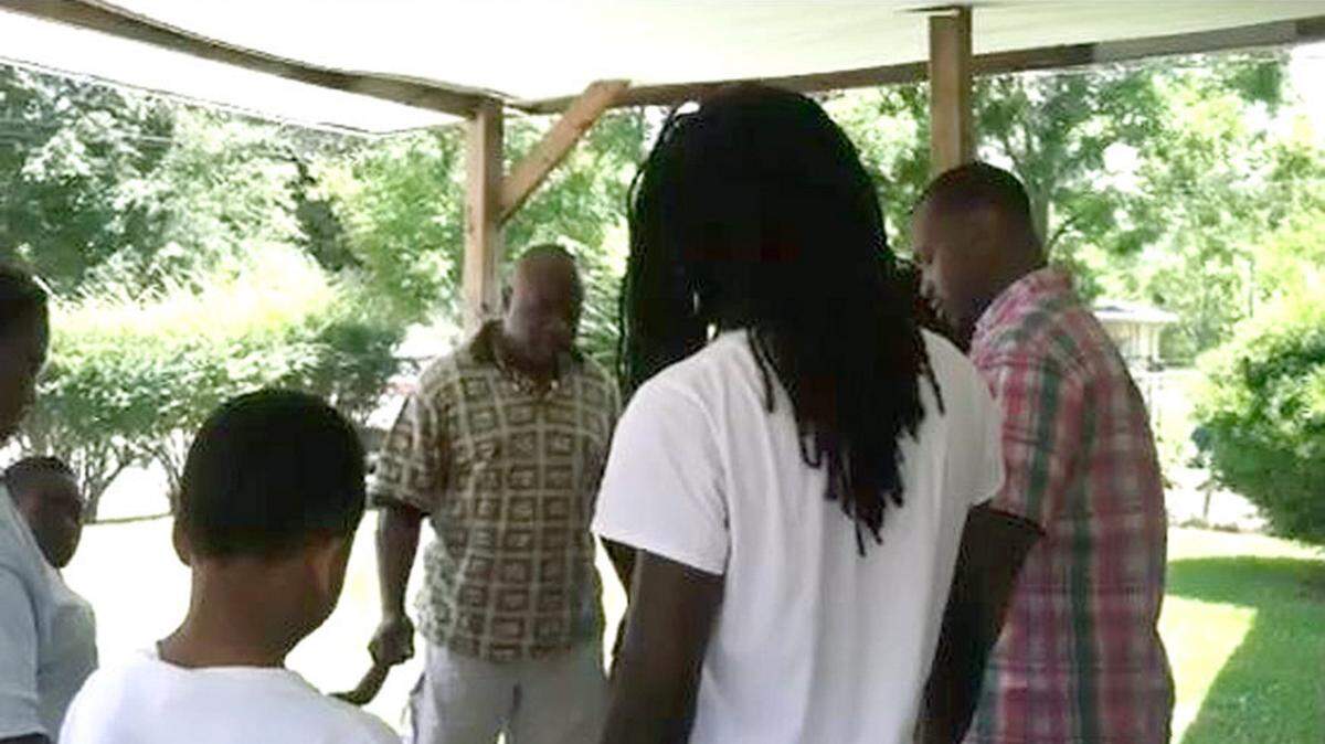 ROBIN FITZGERALD/SUN HERALD 
 The Rev. Kimble Otis joins hands with family of Chavis Allen as he prays for them at Allen's home. Gulfport police say Allen was shot outside his Dogwood Court home late Tuesday. He died early Wednesday.