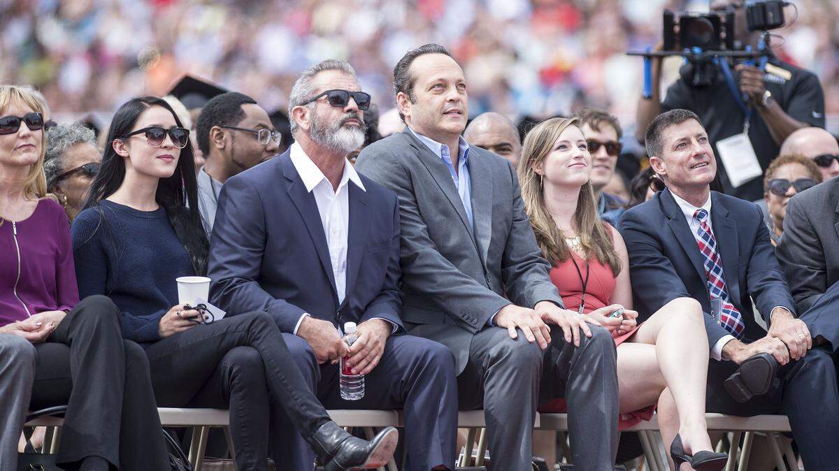 JAY WESTCOTT/NEWS & DAILY ADVANCE via APActors Mel Gibson and Vince Vaughn watch Liberty University's graduation on Saturday in Lynchburg, Va.