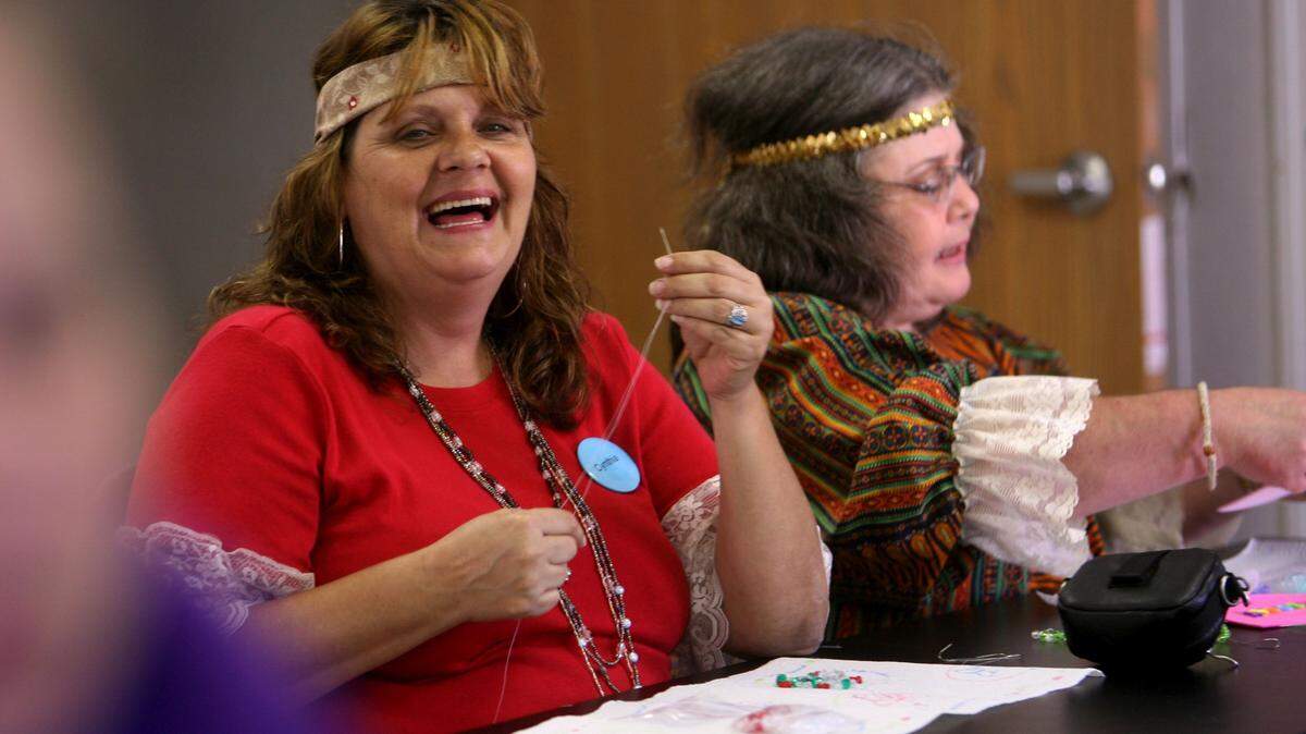 WILLIAM COLGIN/SUN HERALD/2009Cyndie Abercrombie, left, and Anne Harvey string colored beads together during a crafts session for Camp Bluebird on Friday. The colors of the beads represent the fight against different types of cancer.