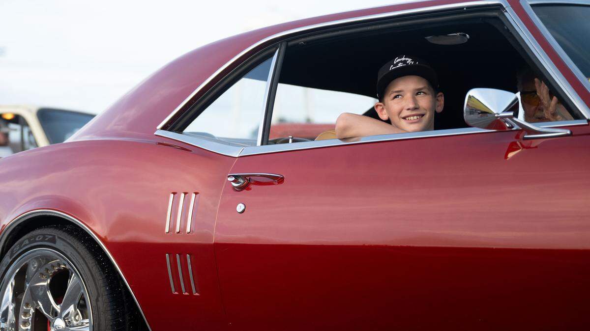A child smiles from the passenger seat of a vintage car during the Long Beach Cruisin’ The Coast Parade on Monday, October. 6, 2025.